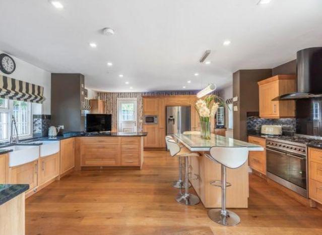 The kitchen is large, with a separate breakfast island, plenty of worktop space and maintains that clean timber detailing throughout.