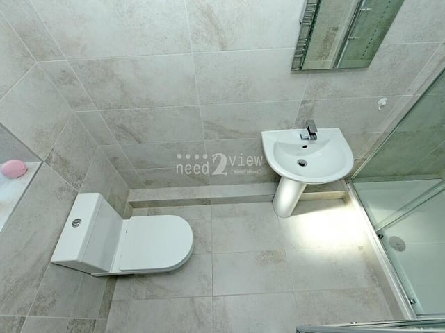 Here is the en suite shower room that is part of the master bedroom. Filly tiled throughout, a three-piece white suite comprises a double shower cubicle, wash hand basin, WC, vanity mirror with light, radiator and ceiling light point.