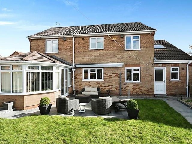 As we step outside, this is the view of the rear of the £420,000-plus house, with the conservatory jutting out to the left. In the foreground is a lovely patio seating area.