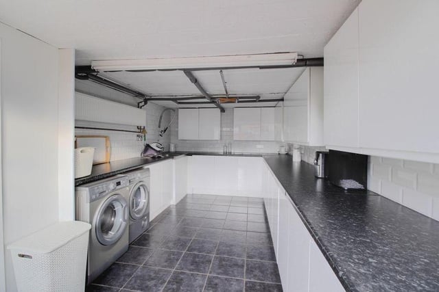 Moving outside now, and this photo shows how the integrated single garage has been converted into a fantastic utility room. As well as storage space and work surfaces, there is room for a washing machine and tumble dryer.