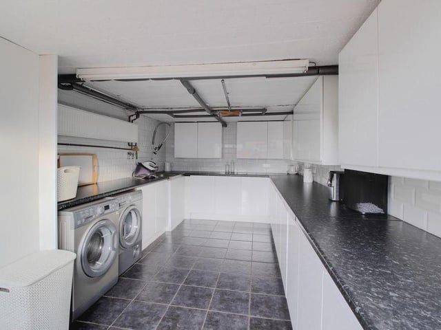 Moving outside now, and this photo shows how the integrated single garage has been converted into a fantastic utility room. As well as storage space and work surfaces, there is room for a washing machine and tumble dryer.