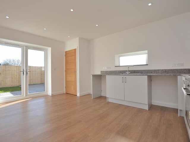 A second look at the kitchen/diner reveals French doors leading out into the garden. There is also an inset stainless steel sink with drainer and mixer tap, plus a built-in storage cupboard housing the gas-fired central heating combi boiler.