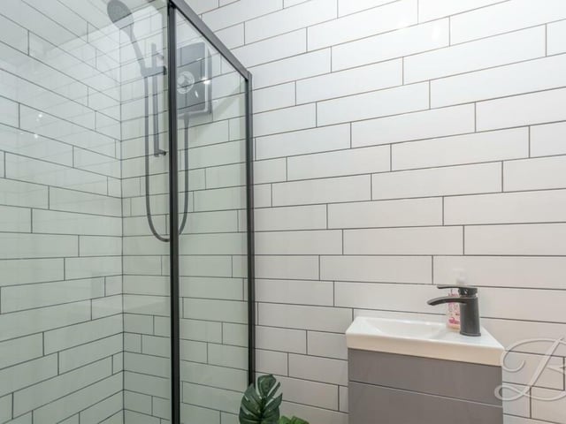 The contemporary, tiled en suite shower room to the master bedroom contains a shower cubicle, hand wash basin and low-flush WC