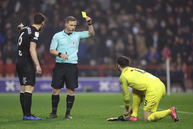 Nathan Baxter of Hull City is shown a yellow card by referee John Busby. That is one of 67 bookings for Hull this campaign.