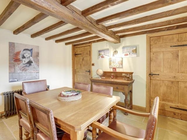 The dining room also possesses an olde-worlde charm, particularly thanks to its exposed beams on the ceiling. Again, there is flagstone flooring, a cast-iron column radiator and wall-light fixtures.