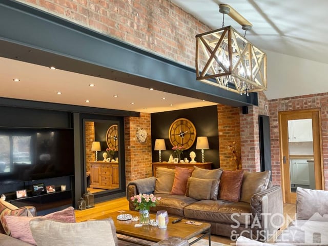 A closer look at the open-plan lounge, with its feature lighting, brick walls and spotlights.