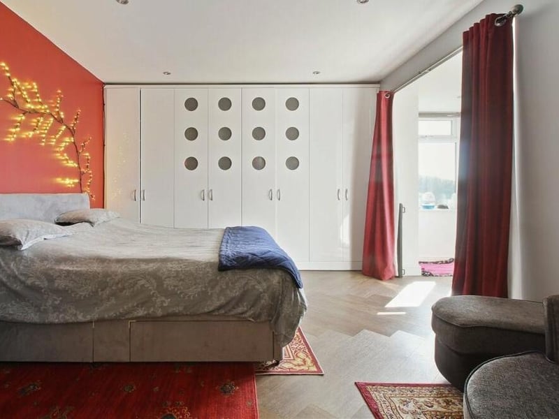This large bedroom on the first floor not only has space for extensive wardrobes but also leads to a dressing room.
