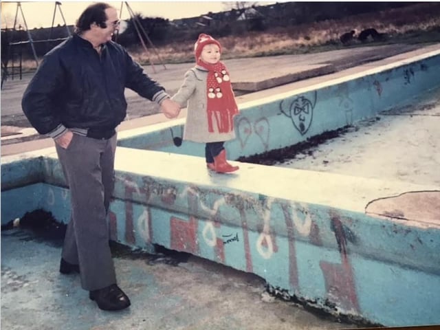 Walt Baines and his granddaughter, Sarah, walking along the abandoned pool after its closure.