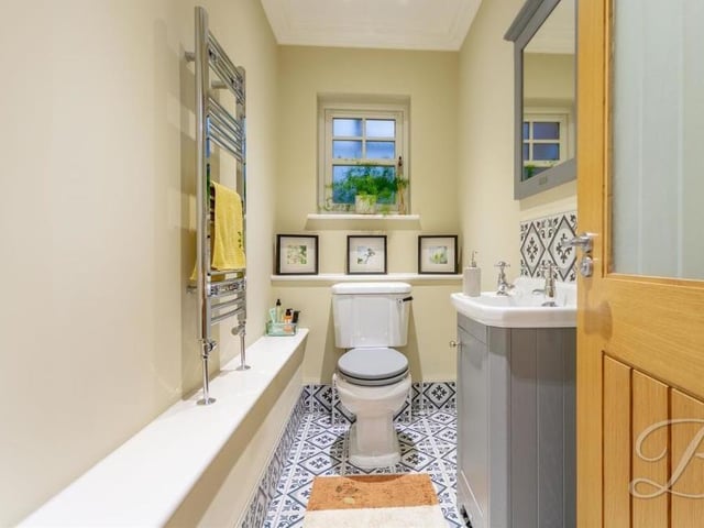 The downstairs toilet comprises a low-flush WC, vanity hand wash basin, tiled flooring and chrome, heated towel-rail.