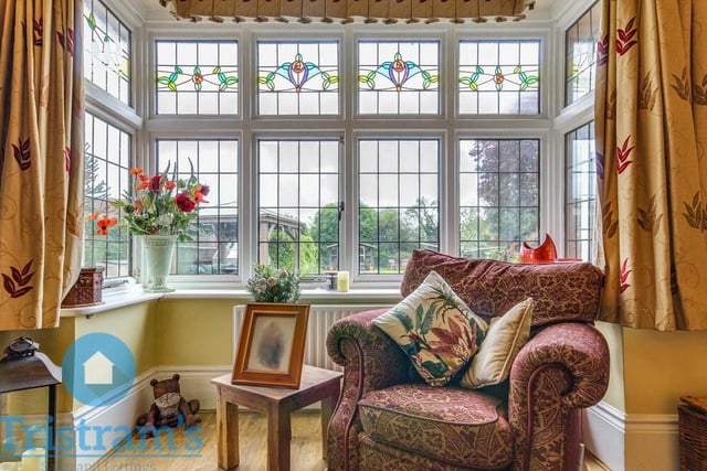 The lovely lounge also features this large, wooden double-glazed bay window overlooking the back of the house.