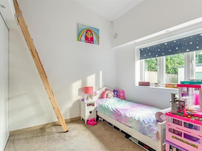 The second bedroom at the bungalow has space for a double bed and boasts fitted wardrobes, with hanging rails, shelves and glossy, sliding doors.