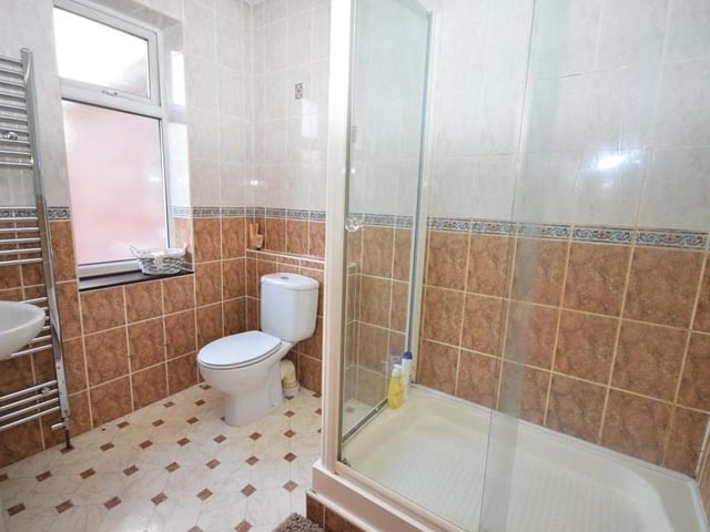 The Ravenshead property features three shower rooms, either as a separate entity (on the ground floor) or as en suite rooms to bedrooms on the first floor. This one has a shower cubicle, low-flush WC, wash basin, chrome heated towel-rail, tiled walls and a tiled floor.