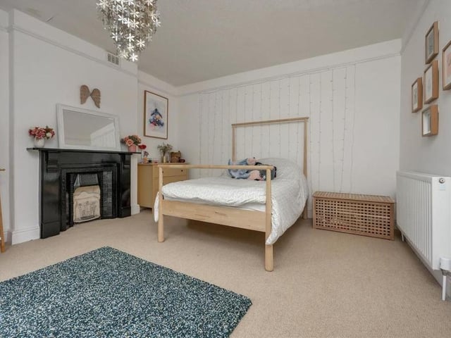 The second double bedroom on the first floor is distinguished by a beautiful cast-iron, painted fireplace. Two floor-to-ceiling, double-glazed sash windows overlook the front of the £615,000 property.
