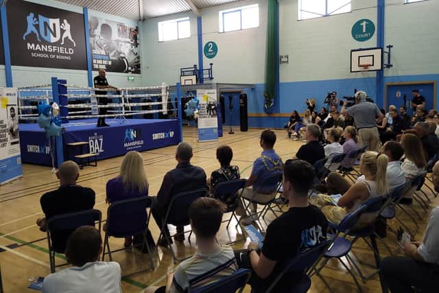 Marcellus Baz addresses a packed audience at the launch event from the boxing ring at the new community hub