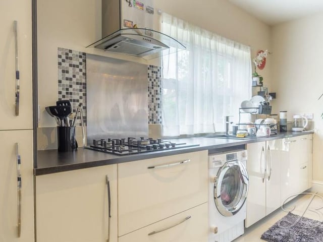 Further appliances within the kitchen diner at the £645,000 bungalow include a gas hob with extractor fan above, and a washing machine.