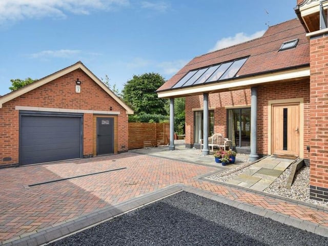 The main driveway at the side of the house provides ample space for off-street parking for numerous vehicles and also leads to a detached double garage with room above.