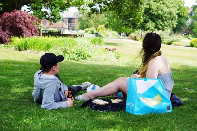 Two people enjoy lunch in the sunshine.