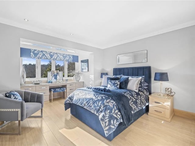 The master features bespoke fitted bedroom furniture including fitted wardrobes, draws and dressing table, feature apex window to the rear aspect, door leading to the en suite, wooden flooring and radiator.