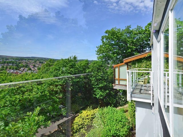 Large glass windows and balconies take advantage of a westerly facing front aspect, with views above the tree line towards Blacka Moor.