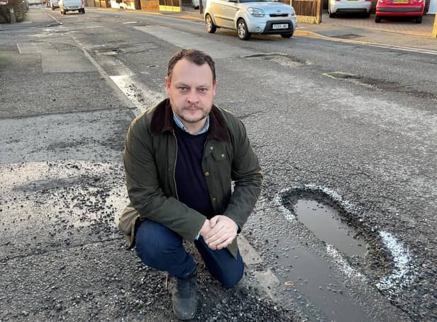 Coun Jason Zadrozny, leader of the Ashfield Independents, next to a dangerous pothole on High Pavement in Sutton.