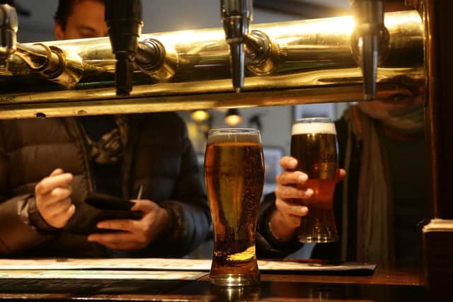 Customers collecting their drinks at a bar. Picture by PA Archive/PA Images.