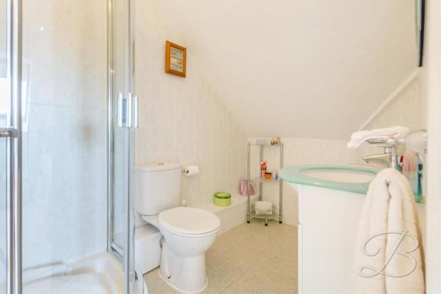 The en suite facilities to bedroom five at the Ravenshead house comprise an enclosed shower, low-flush WC and vanity unit.
