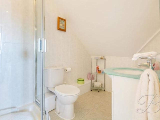 The en suite facilities to bedroom five at the Ravenshead house comprise an enclosed shower, low-flush WC and vanity unit.