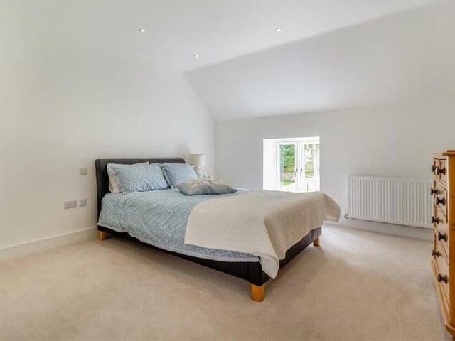 Along an additional landing, you will come across the other two bedrooms at the £625,000 house. Here is number two, another spacious double, with nine ceiling spotlights and a narrow slit-window feature.