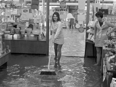 16-year-old Karen Ball swept the flood water at Linneys on Westgate.