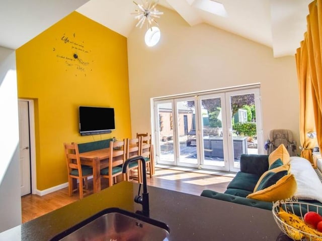 This photo shows how the kitchen opens out to form a dining area and a place to relax, with garden views to boot.