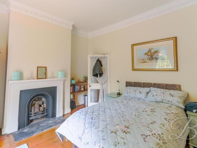 Bedroom number six has wooden-plank flooring, a feature fireplace, coving and hand wash basin. The window overlooks the front of the property.