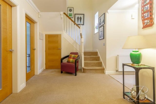 As we prepare to go up to the first floor, let's pass through the welcoming hallway, which has a carpeted floor and useful storage cupboards, as well as the staircase.