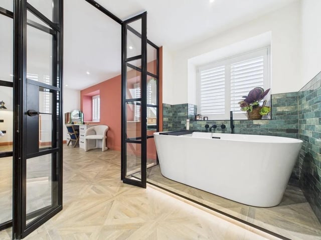 The en suite bathroom features a freestanding bath, separate shower, and elegant fixtures.