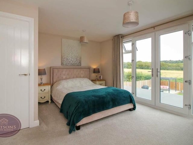 On the first floor, the primary bedroom is a terrific space, particularly as it boasts uPVC double-glazed French doors that lead to a glass Juliet balcony offering views of the rear garden and beyond.