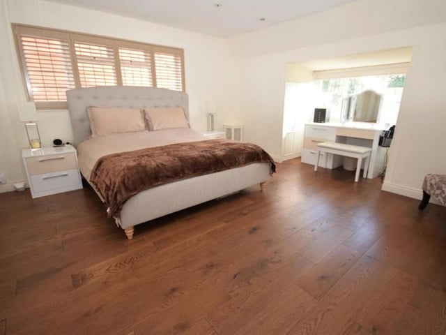 As we move upstairs, a long landing leads to the four bedrooms. This is the spacious principal double, which is a calm and peaceful retreat with its tasteful decor of neutral tones.