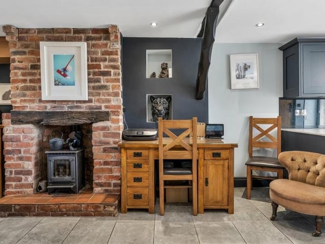 A feature of the open-plan living area at Lea Cottage is this feature gas fireplace with brick surround.