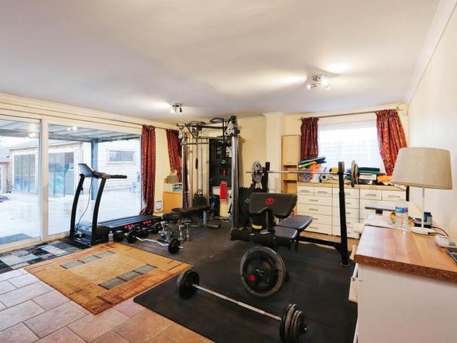 The living room or lounge within the lower-level annexe is currently being used as a fully functional gym. The room has access, via sliding doors, to the patio area in the garden.