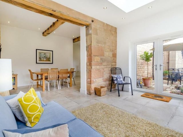 The dining kitchen flows seamlessly into this orangery extension, which is a fantastic garden room, complete with ceiling lantern that floods light into the space. Spot also another exposed stone wall.