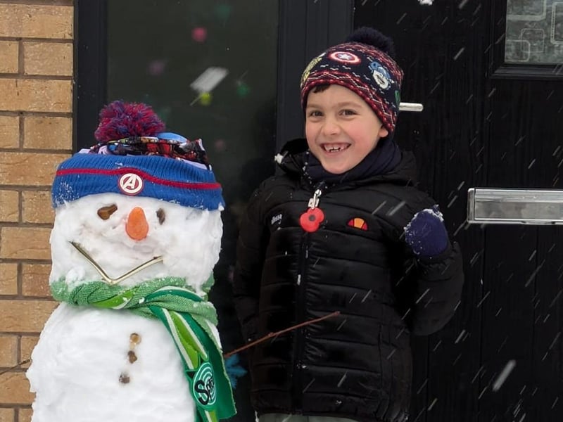 Albert Prady, six, with his snowman he made with his dad