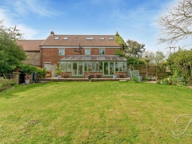 Let's step outside now for a few images of the exterior of the £750,000 property. This is the rear, with one of the conservatories facing the back garden, which is mainly laid to lawn, surrounded by mature planted borders.