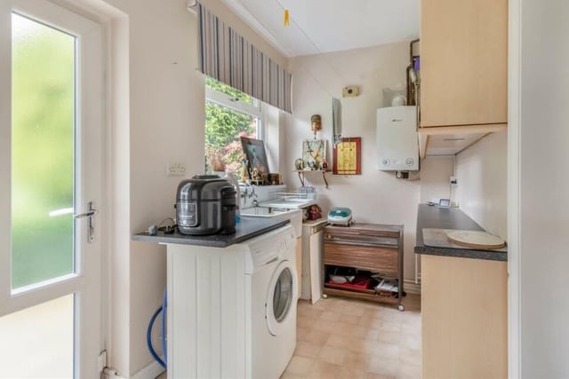 Just off the kitchen is this handy utility room, which contains space and plumbing for a washing machine, and also a wall-mounted central heating boiler. Other features include laminate work surfaces, an inset Belfast sink and wall and base units that boast display cabinets with glass shelves.