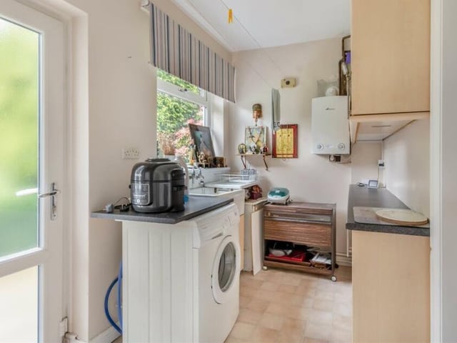 Just off the kitchen is this handy utility room, which contains space and plumbing for a washing machine, and also a wall-mounted central heating boiler. Other features include laminate work surfaces, an inset Belfast sink and wall and base units that boast display cabinets with glass shelves.