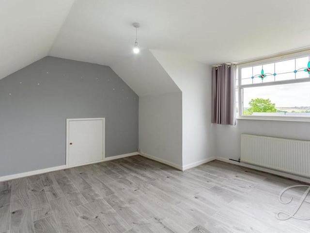 The third bedroom, built into a space in the roof of the bungalow. The floor is carpeted and the window overlooks the front of the property.