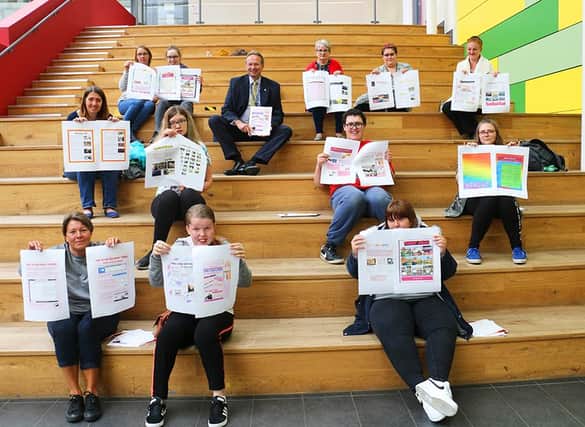 Practical work skills students proudly display their creative pages with staff and principal Andrew Cropley (centre, top)