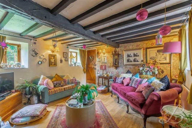 Moving on from the breakfast kitchen, we come to the beautiful and comfortable living room, which features exposed ceiling beams and windows to the side of the Church Road property.