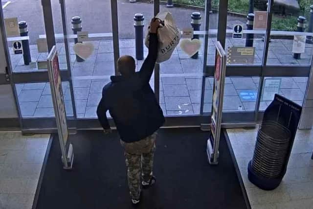 The suspect brazenly lifted the bag of stolen items over the alarm system on their way out of the shop