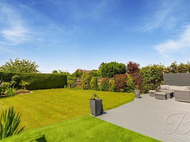 A handful of exterior photos to show you now, beginning with this one of the stunning rear garden. There's a decked seating area, from where steps lead down to an extensive, well-maintained lawn with surrounding mature shrubs, trees and hedges that deter any nosey neighbours!