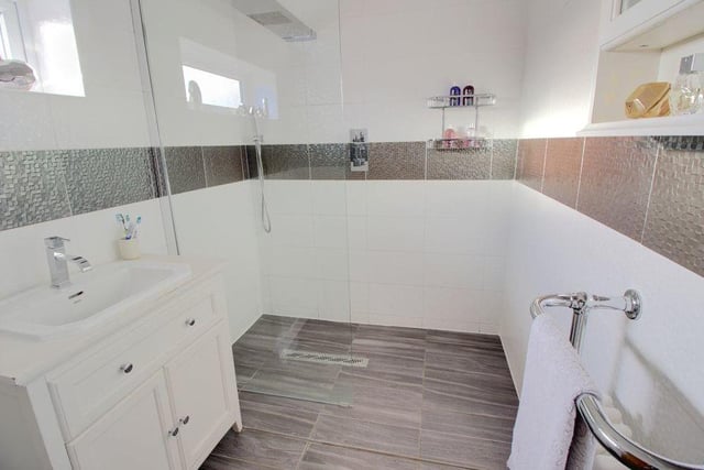 Also to be found on the first floor is this spacious bathroom, which is fully tiled and features a large and modern walk-in shower, as well as a wash hand basin and WC.