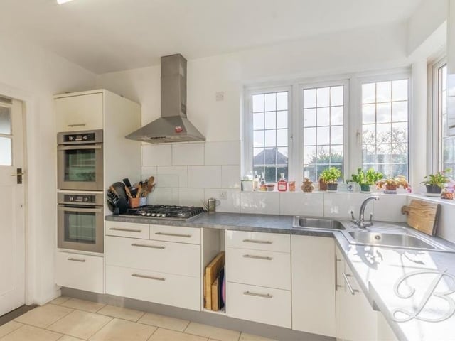 Next stop on our tour of the £560,000 house is this fabulous kitchen, where integrated appliances include a double oven, gas hob with stainless steel extractor fan above, and dishwasher. Windows overlook the side and back of the property.