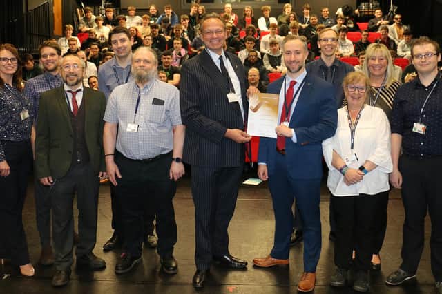 Principal Andrew Cropley (centre) presents the computer science team with their bronze winner certificate at a celebration event attended by students and staff.